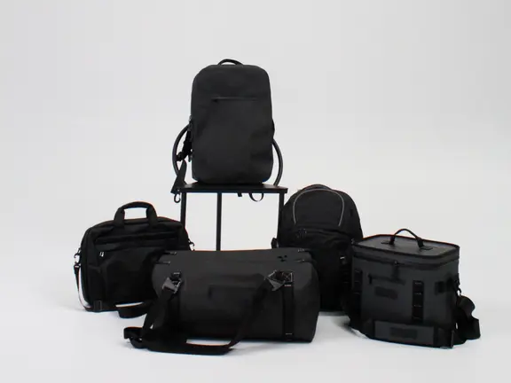 Black backpacks, duffel and cooler bags on a studio set